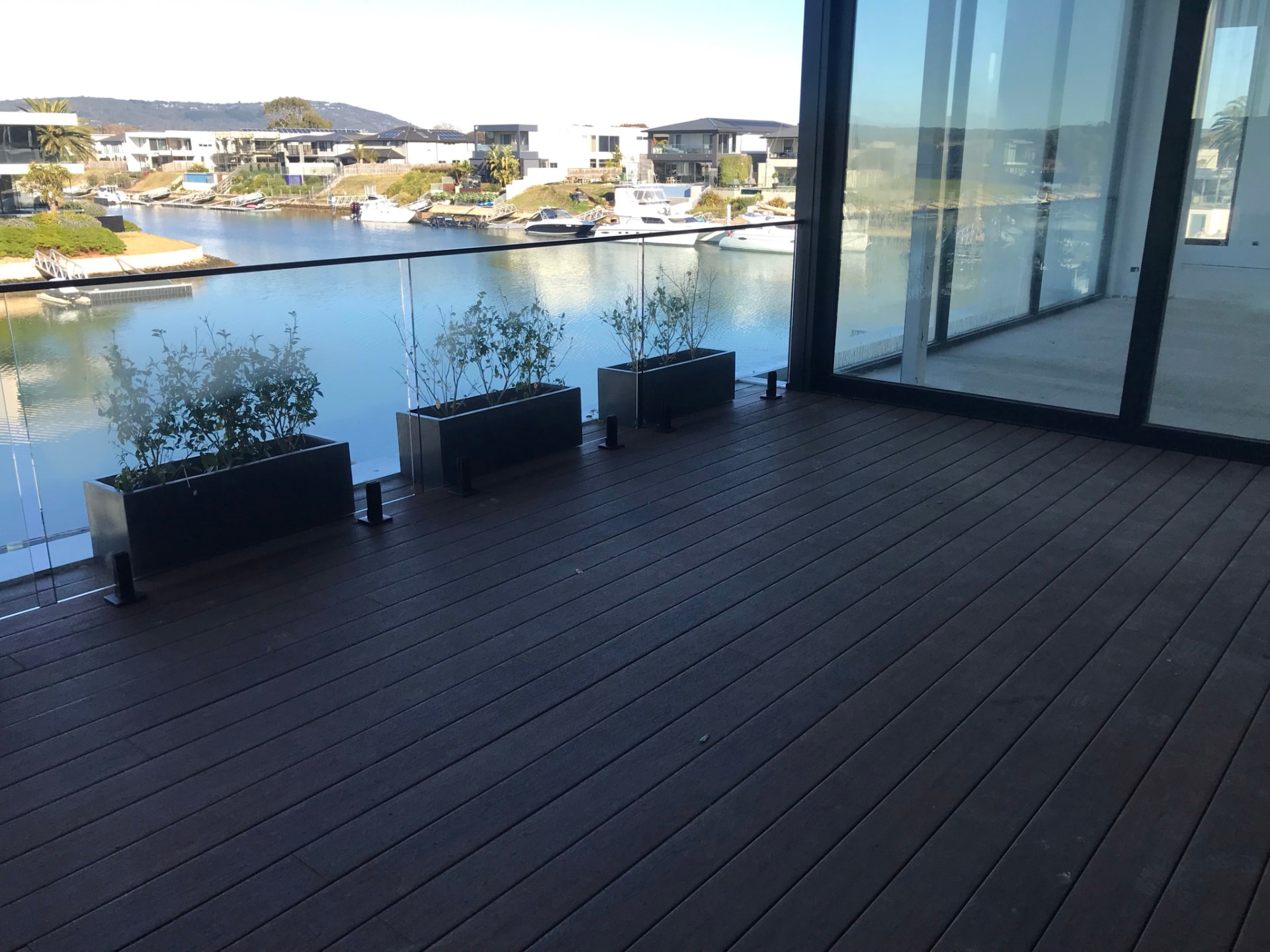 Dark composite deck on a waterfront home overlooking a marina with boats